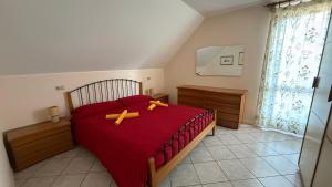 a bedroom with a red bed with two bananas on it at Appartamento Belvedere in Teglio