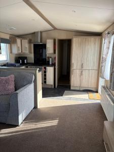 a living room with a couch and a kitchen at Sunrise in Selsey