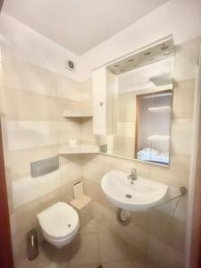 a white bathroom with a sink and a toilet at Noclegi Lux Nysa in Nysa