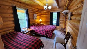 a bedroom with two beds in a log cabin at Domaine Valga in Saint-Gabriel