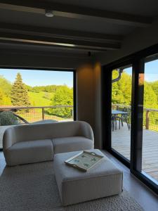 a living room with a couch and a large window at Chosen Hideaway Near Cologne in Neunkirchen-Seelscheid