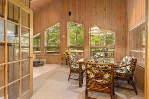 a dining room with a table and chairs and windows at Causeway On Gull - 2 Bedroom in Nisswa