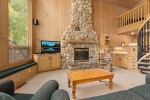 a living room with a fireplace and a tv at Causeway On Gull - 2 Bedroom in Nisswa