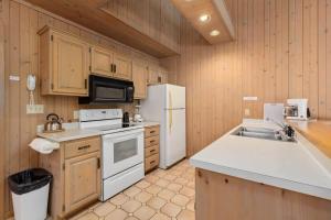 a kitchen with a white refrigerator and a sink at Causeway On Gull - 2 Bedroom in Nisswa +6 photos