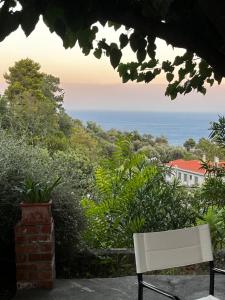 a white bench sitting in front of the ocean at The Arch House in Kymi