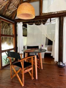 a table and chairs in a room with a bed at Ecolodges La Nuit in La Vega +28 photos