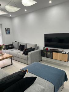 a living room with a couch and a flat screen tv at Apparemment Martil Sofia bay in Martil