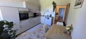 a kitchen with white cabinets and a wooden table at Auszeit im Grünen in Vohenstrauß