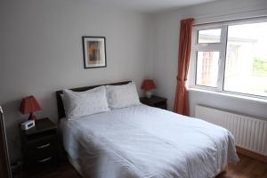 a bedroom with a white bed and a window at Avalon in Bundoran