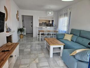 a living room with a blue couch and a table at El sueño de Rocío in Roquetas de Mar
