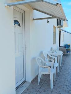 a row of white tables and chairs on a patio at Vivenda Becho in Alpalhão