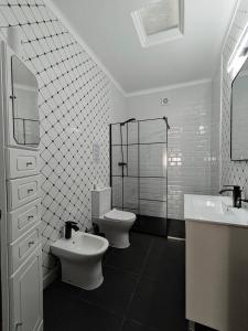 a bathroom with two toilets and two sinks and a shower at Vivenda Becho in Alpalhão +18 photos