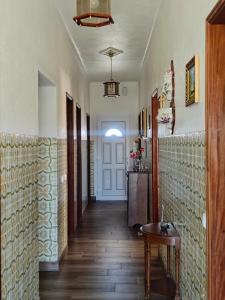 a hallway of a house with a table and a door at Vivenda Becho in Alpalhão