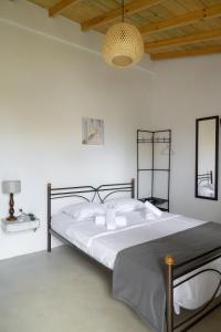 a bedroom with a large bed with white walls at Kyklades Sensation Private Plunge Pool Romantic Suite in Artemida