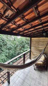 a hammock on a porch of a house at Pousada Cantarel in Maricá