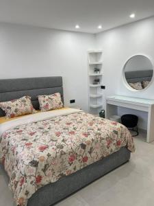 a bedroom with a bed and a desk and a mirror at Apparemment Martil Sofia bay in Martil