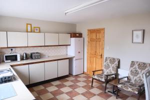 a kitchen with two chairs and a white refrigerator at Avalon in Bundoran +6 photos