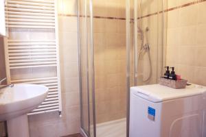 a bathroom with a shower and a toilet and a sink at The River House in Bagnone