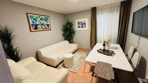 a living room with a white couch and a table at Ava Apartments in Omišalj