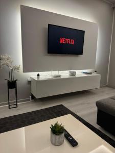 a living room with a television on a white wall at Zora Apartman in Veszprém