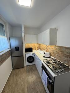 a kitchen with a stove and a refrigerator at Zora Apartman in Veszprém