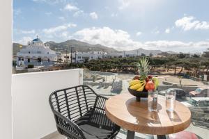 a wooden table with a bowl of fruit on a balcony at Rafaela Casa Luxury Apartment Naxos in Naxos Chora
