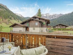 a wooden deck with a house in the mountains at Alpenchalet mit Charme in Lenk