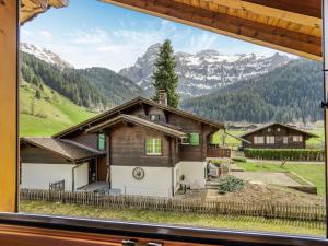 a house in the mountains viewed through a window at Alpenchalet mit Charme in Lenk