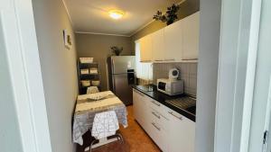 a small kitchen with a microwave and a refrigerator at Ava Apartments in Omišalj