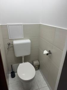 a bathroom with a toilet and a toilet paper dispenser at Zora Apartman in Veszprém +3 photos