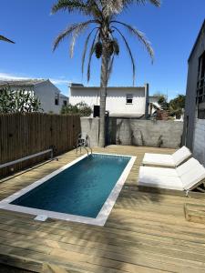 a swimming pool on a wooden deck with a palm tree at Pedre Loft in La Pedrera