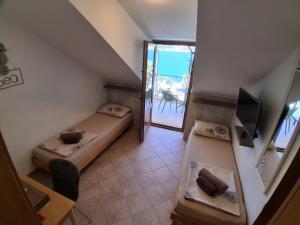 a small room with two beds and a balcony at Guesthouse Anita in Kotor
