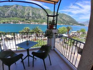 a balcony with a table and chairs and a view of the ocean at Guesthouse Anita in Kotor