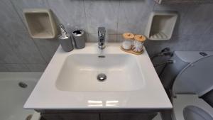 a bathroom with a white sink and a toilet at Saint George Terrace House in Chios +10 photos