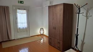 a room with a wooden cabinet and a window at Saint George Terrace House in Chios