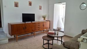 a living room with a tv on a wooden dresser at Saint George Terrace House in Chios