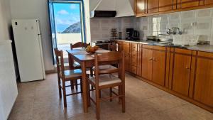 a kitchen with a table and chairs and a kitchen with a window at Saint George Terrace House in Chios
