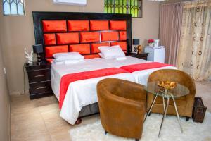 a bedroom with a large bed and a glass table at Guesthouse Gabby in Klerksdorp
