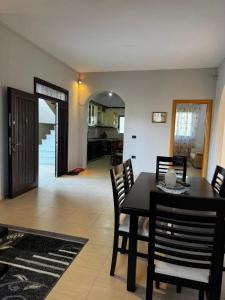 a dining room with a black table and chairs at Garden House - Hamallaj in Hamallë