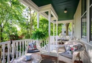 a porch with wicker chairs and a table at Avery House Bed & Breakfast in Galena