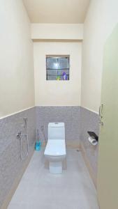 a bathroom with a toilet and a window at Celeste Inn in Shillong