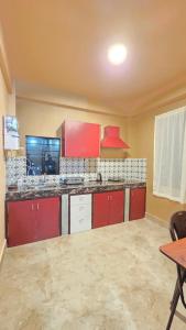 an empty kitchen with red cabinets and a table at Celeste Inn in Shillong