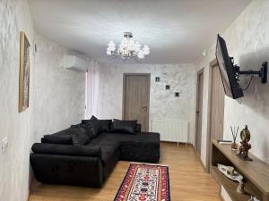 a living room with a black couch and a chandelier at Vila Dari in Tulcea