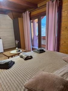 a bedroom with a large bed with a large window at Готель Близнюки in Vorokhta