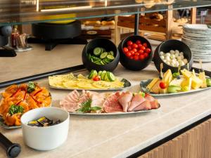 a buffet with several plates of food on a counter at Mercure Salzburg City in Salzburg