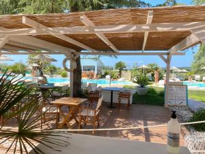 eine Terrasse mit Tischen und Stühlen und ein Pool in der Unterkunft La Siègià Resort spa in Massa Marittima