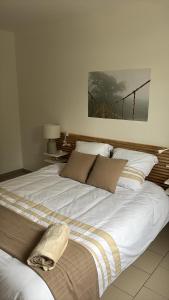 a large white bed in a white room with at la maison de montpon in Montpon-Ménestérol