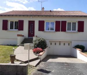 a house with a red door and a garage at Maison Treize vents in Treize-Vents