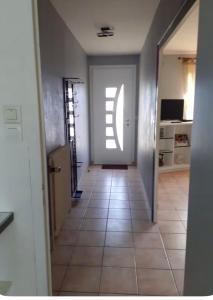 a hallway with a door and a tile floor at Maison Treize vents in Treize-Vents +2 photos
