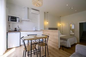 a kitchen and living room with a table and chairs at Hotel Boutique Alcazaba Salobreña in Salobreña